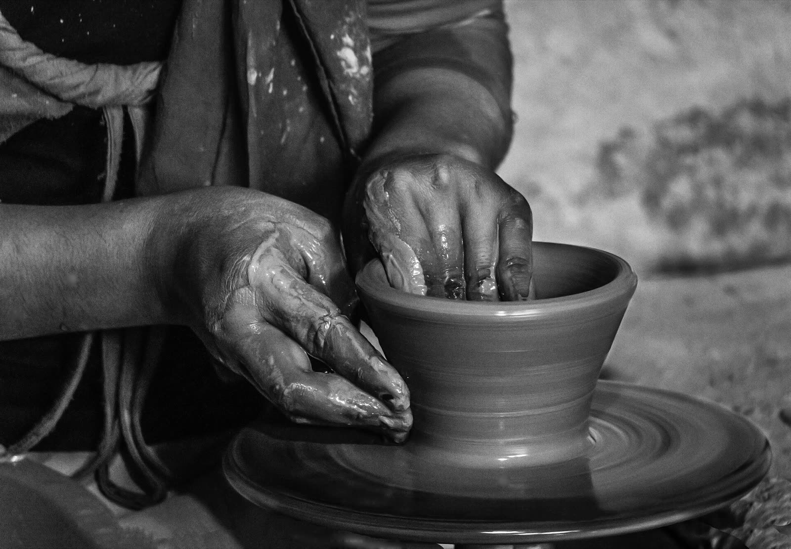 Hands shaping wet clay at a pottery workshop in Tunis village, Fayoum