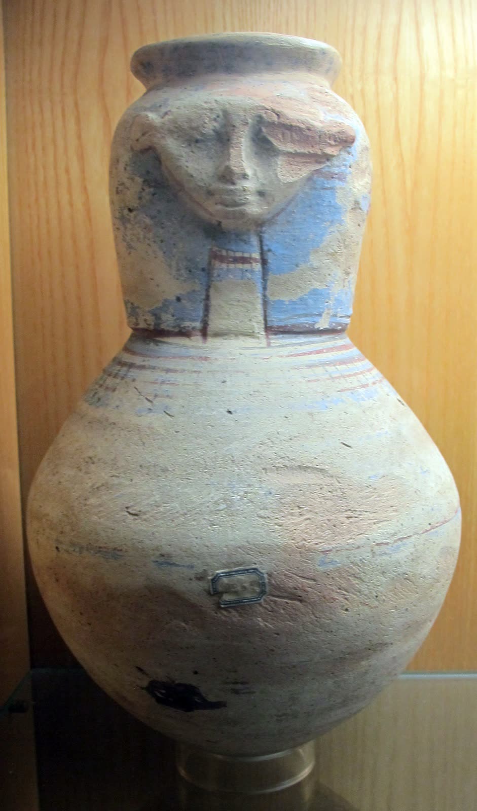 Ancient Egyptian terracotta vessels with narrow, rounded and shouldered profiles in a museum display